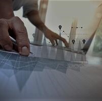 business documents on office table with smart phone and laptop computer and graph business with social network diagram and man working in the background